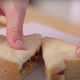Person pulling PB&J sandwich apart